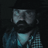 a man with a beard is wearing a hat and earrings and the words of course it is written in pink