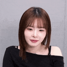 a woman wearing a black off the shoulder top