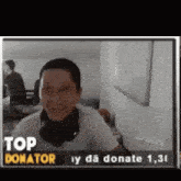 a man wearing headphones is smiling in front of a sign that says top donor
