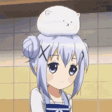 a girl with a cat on her head is sitting in a kitchen .