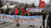 a group of people are holding a banner that says kke