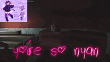 a cat is sitting on a table next to a neon sign that says " you are so nyan "