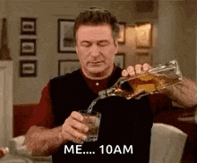 a man is pouring a glass of whiskey into a glass .