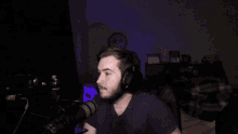 a man wearing headphones is sitting in front of a microphone in a dark room