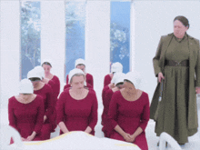 a group of women wearing red dresses and white hats