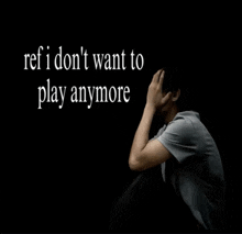 a man sits with his head in his hands with the words ref i don 't want to play anymore above him
