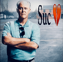 a man stands with his arms crossed in front of a sign that says suc on it
