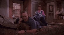 a man laying on a bed talking on a phone