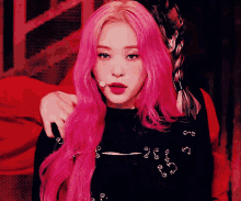 a woman with pink hair is wearing a black shirt