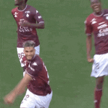a soccer player wearing a shirt that says mosl car avenue is celebrating