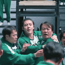 a group of men in green uniforms are playing a game .