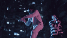 a man in a white sweater is dancing with another man in a striped shirt