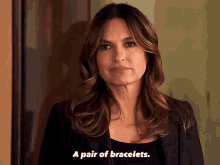 a woman is talking about a pair of bracelets while wearing a black jacket .