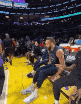 a basketball player sits on a bench during a game