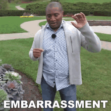 a man standing in a park with the word embarrassment written on the bottom