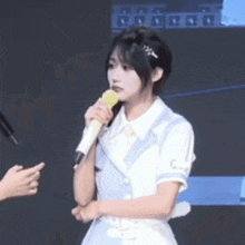 a woman is holding a microphone in her hand and talking to a man .