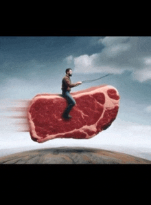 a man is riding a large piece of meat in the sky