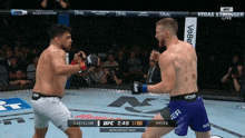 two men are fighting in a boxing ring with the ufc logo on the bottom