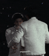 two men in white jackets are hugging each other with a caption that says ' ongebebsie ' on the bottom