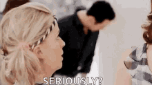a woman is talking to another woman while a man looks on .