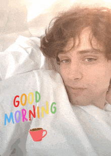 a man is laying in bed wearing a shirt that says " good morning "