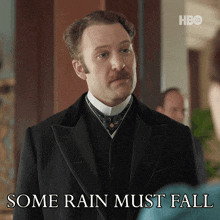 a man in a suit says some rain must fall in front of him