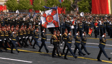 a marching band is marching down the street with a flag that says ' victory ' on it