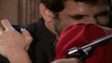 a man is holding a gun and a woman is holding a red cloth