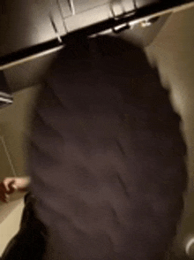 a person wearing a black hat is standing in a kitchen .