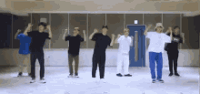 a group of young men are standing in a room dancing together .