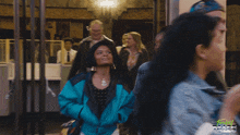 two women are standing next to each other in front of a freaky tales ad
