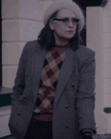 a woman wearing a striped jacket and plaid sweater