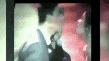 a blurry picture of a man and woman kissing on a red background