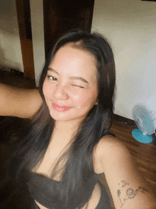 a woman with a tattoo on her arm winks