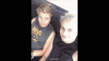 a man wearing a nirvana shirt is laying on a bed with another man .