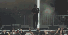 a man singing into a microphone in front of a crowd with a sign that says ' a few dollars more '