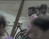 a group of men are standing in front of a bicycle and one of them is smoking a cigarette