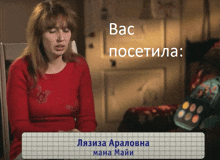 a woman in a red sweater sits in front of a sign that says вас посетила