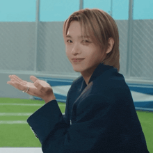 a man wearing a blue jacket and a ring on his finger