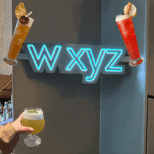 a neon sign that says wxyz hangs on a wall