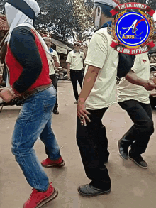 a group of people are dancing in front of a logo that says the big family