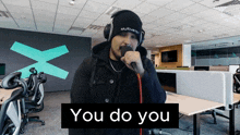 a man singing into a microphone with the words you do you on the bottom