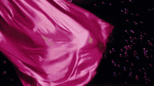 a pink cloth is being blown by the wind