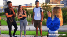 a group of people standing next to each other in a park