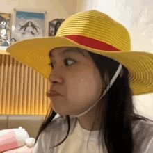 a woman wearing a yellow hat with a red ribbon around her neck .