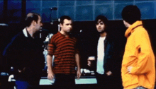 a man in a yellow jacket talks to a group of men