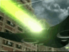 a green light is coming from a black object in the sky