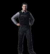 a man is dancing in front of a black background .