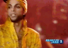 a man in a yellow jacket is standing in front of arsenio 1 jams
