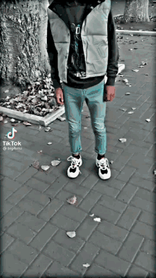 a man standing on a brick sidewalk with a tik tok watermark